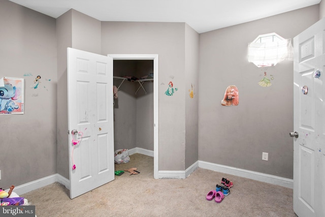 carpeted bedroom with a walk in closet and a closet