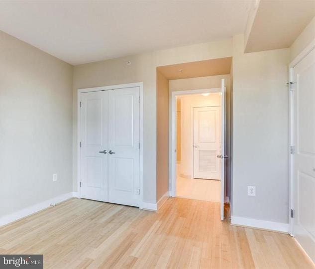 unfurnished bedroom featuring light hardwood / wood-style floors and a closet