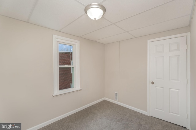 spare room with carpet floors and a paneled ceiling