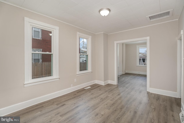 empty room featuring crown molding and light hardwood / wood-style floors