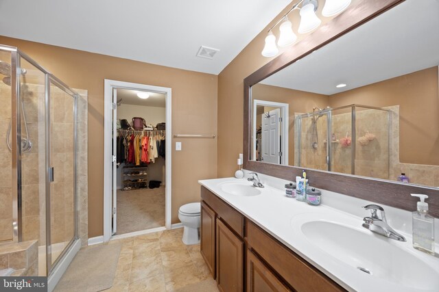 bathroom featuring vanity, tile patterned flooring, toilet, and walk in shower