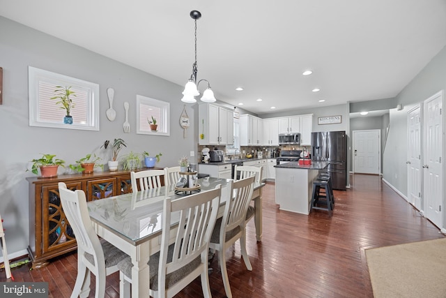 dining area with dark hardwood / wood-style flooring, sink, and a notable chandelier