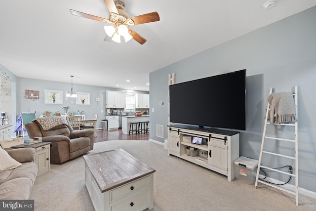 living room featuring light colored carpet and ceiling fan