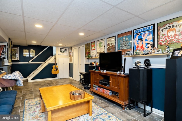 living room featuring a drop ceiling and dark tile patterned floors