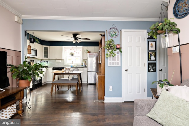 living room featuring sink, ornamental molding, dark hardwood / wood-style floors, and ceiling fan