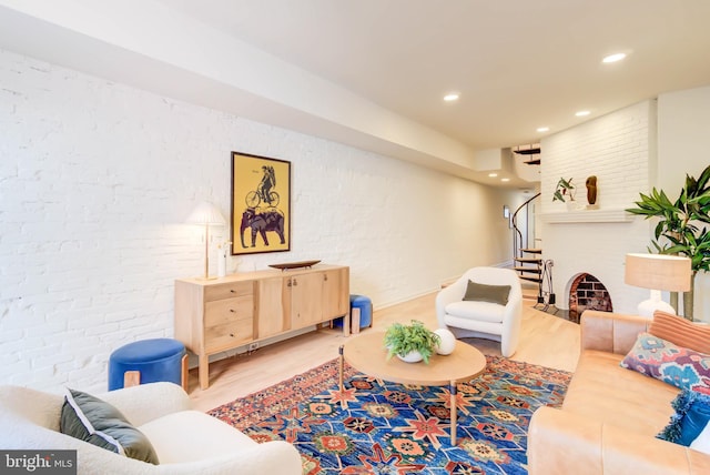 living room with wood-type flooring and brick wall