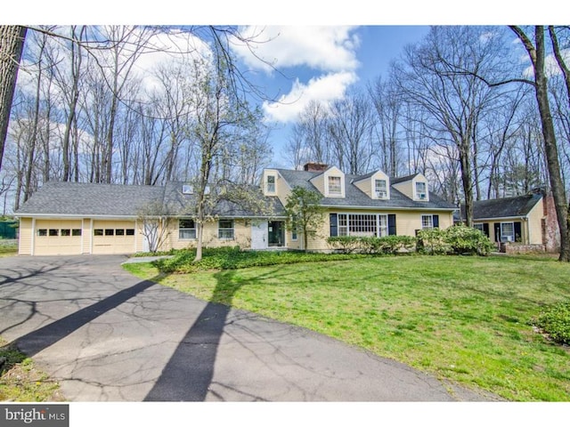 cape cod-style house with a garage, a front yard, and driveway