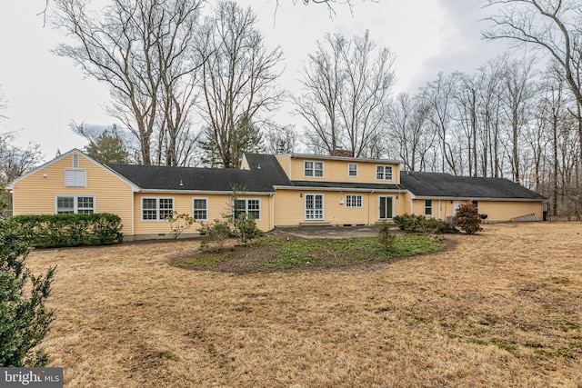 rear view of property featuring crawl space, a patio area, a chimney, and a yard