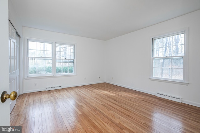 unfurnished room featuring light wood-style flooring, visible vents, and baseboards