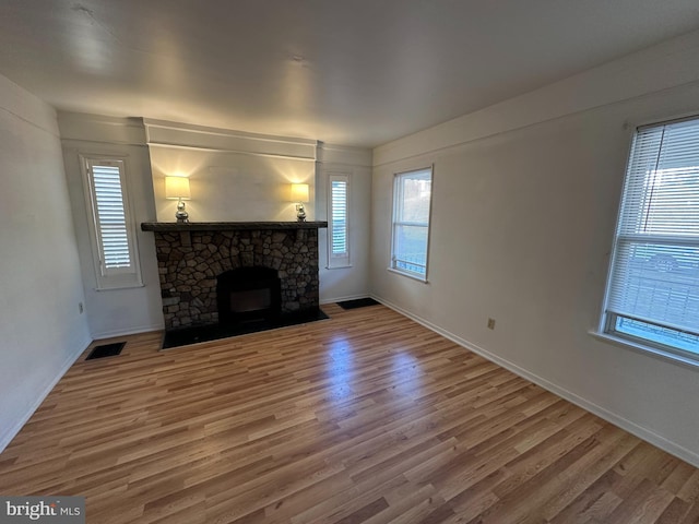 unfurnished living room with a fireplace and hardwood / wood-style floors