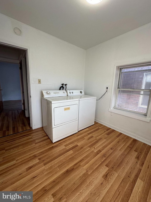 laundry area with washer and clothes dryer and light hardwood / wood-style floors