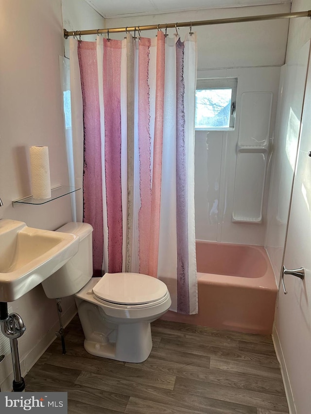 bathroom featuring wood-type flooring, shower / bath combination with curtain, and toilet