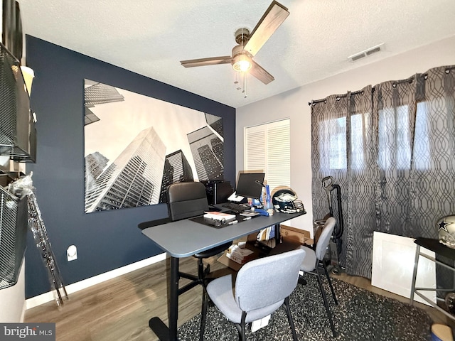 home office featuring ceiling fan, a textured ceiling, and dark hardwood / wood-style flooring