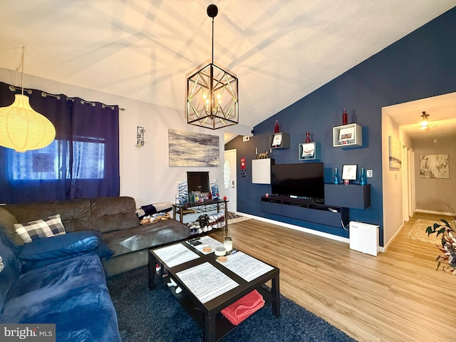 living room featuring hardwood / wood-style flooring, vaulted ceiling, and an inviting chandelier