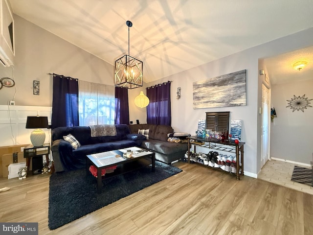 living room with lofted ceiling, a notable chandelier, and wood-type flooring