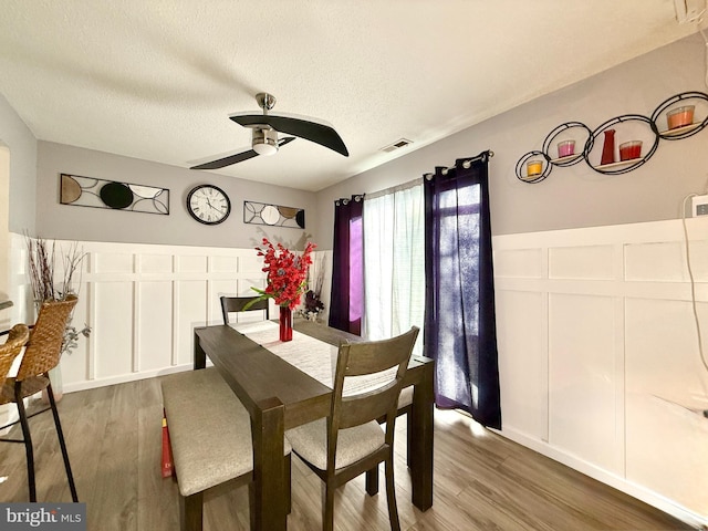 dining room featuring ceiling fan, dark hardwood / wood-style flooring, and a textured ceiling