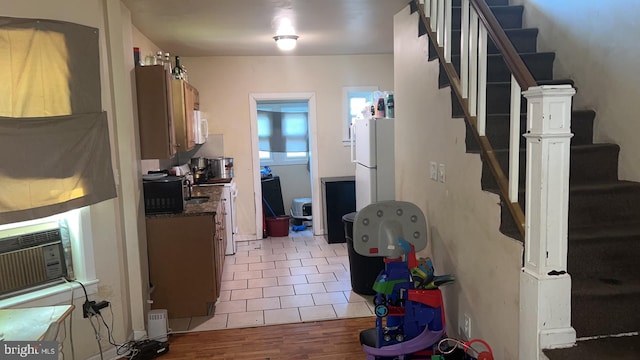 kitchen featuring dark stone countertops, cooling unit, white appliances, and wood-type flooring