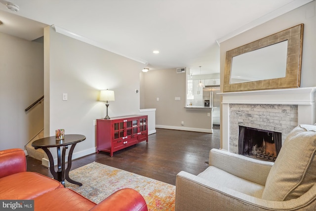 living room with visible vents, baseboards, recessed lighting, a fireplace, and wood finished floors