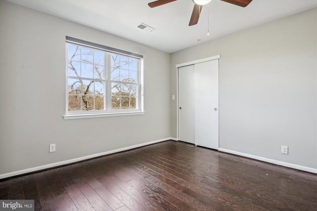 unfurnished bedroom featuring visible vents, baseboards, a closet, a ceiling fan, and wood-type flooring