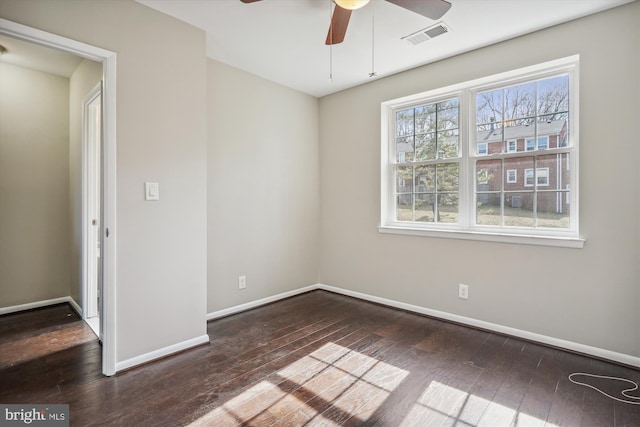 unfurnished room featuring visible vents, baseboards, hardwood / wood-style floors, and a ceiling fan