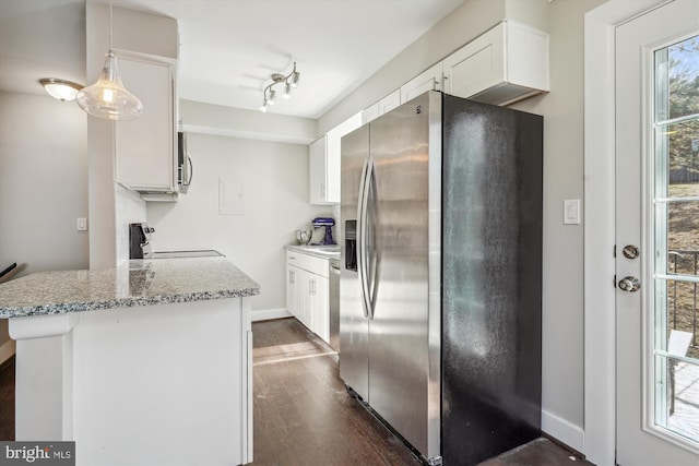 kitchen with dark wood-style floors, appliances with stainless steel finishes, white cabinetry, and light stone counters