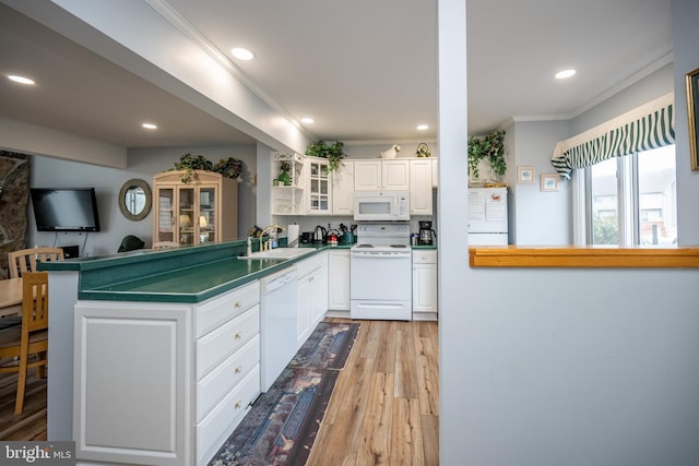 kitchen with sink, white cabinets, white appliances, and kitchen peninsula