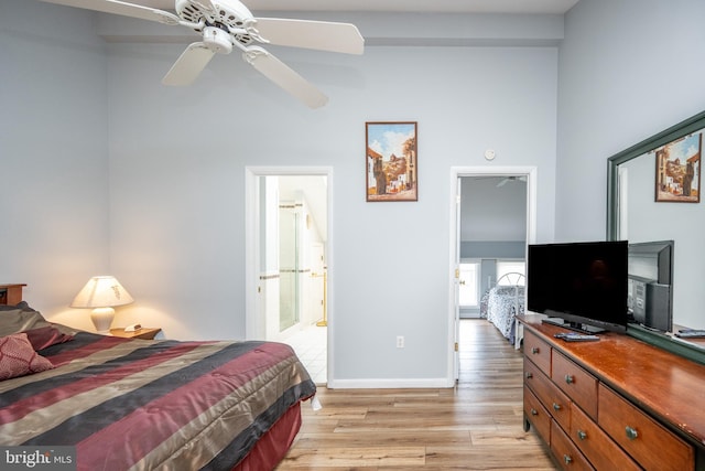 bedroom with ceiling fan, connected bathroom, and light wood-type flooring