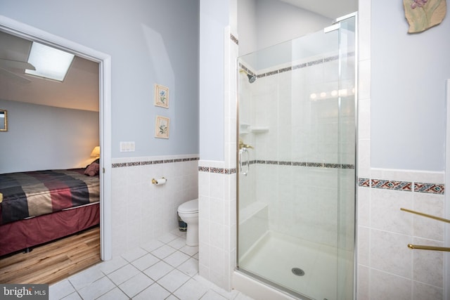 bathroom with tile walls, an enclosed shower, tile patterned floors, and toilet