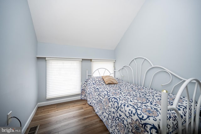 bedroom featuring hardwood / wood-style flooring and vaulted ceiling