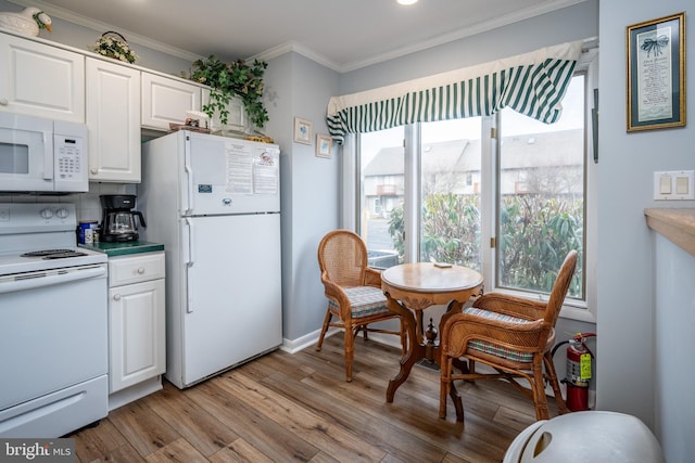 kitchen featuring crown molding, light wood-type flooring, white cabinets, and white appliances