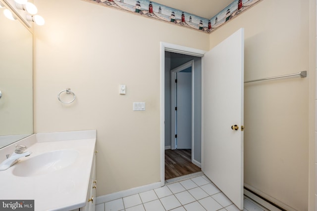 bathroom with tile patterned flooring, vanity, and baseboard heating