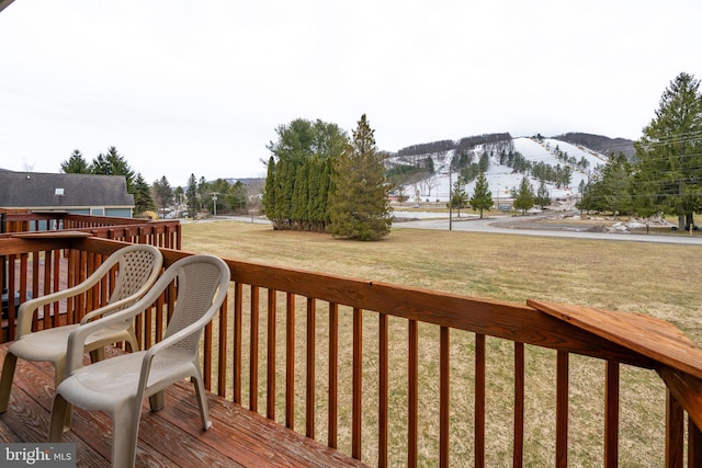 wooden terrace featuring a yard and a mountain view