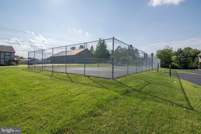 view of tennis court featuring a lawn