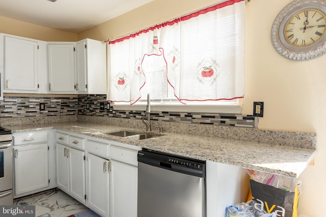 kitchen with stainless steel appliances, sink, white cabinets, and light stone counters