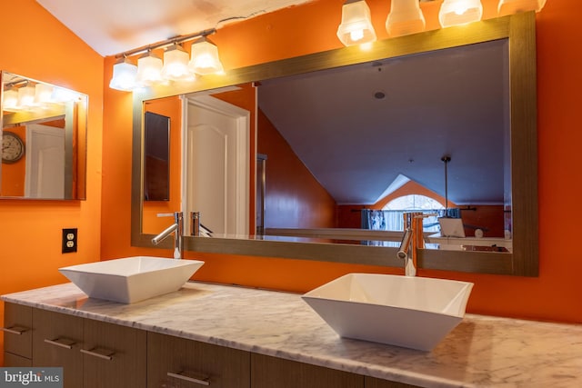 bathroom with vanity and vaulted ceiling