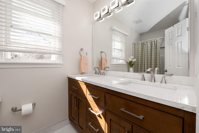 bathroom with vanity, vaulted ceiling, and a wealth of natural light