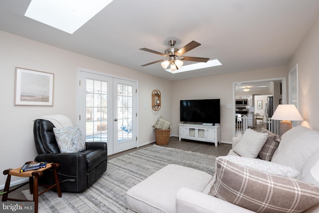 living room with french doors, ceiling fan, a skylight, and hardwood / wood-style flooring