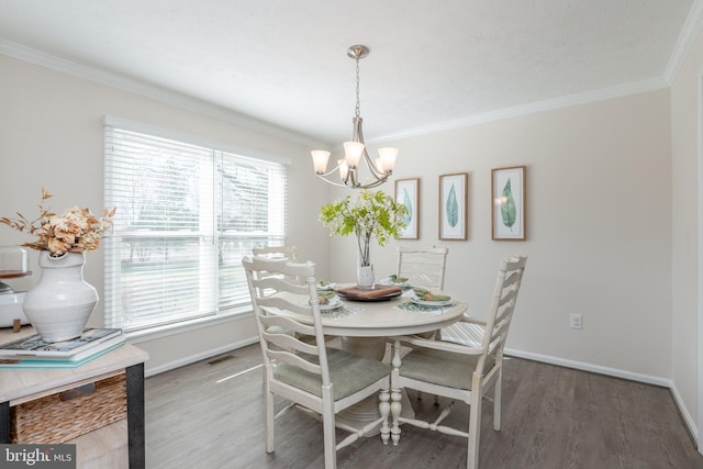 dining area featuring an inviting chandelier, hardwood / wood-style floors, and ornamental molding