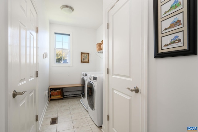 clothes washing area featuring light tile patterned floors and washing machine and clothes dryer