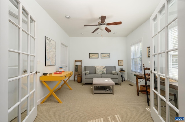 carpeted living room featuring french doors and ceiling fan