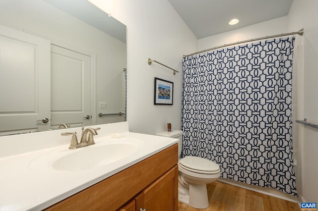 bathroom featuring hardwood / wood-style flooring, vanity, toilet, and walk in shower