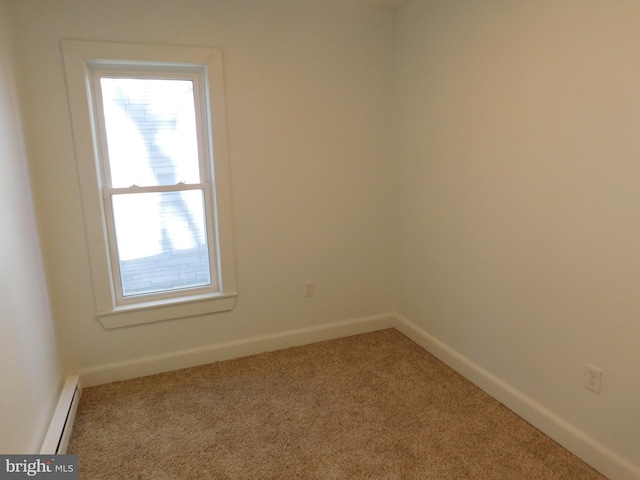 carpeted empty room featuring baseboard heating