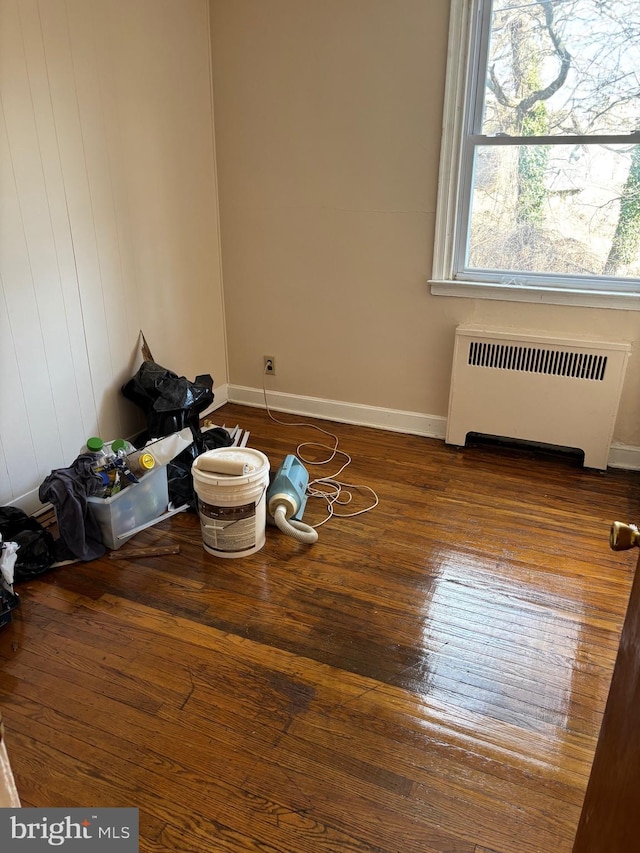 empty room with radiator and hardwood / wood-style floors