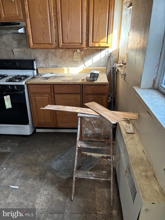 kitchen with backsplash and gas range oven