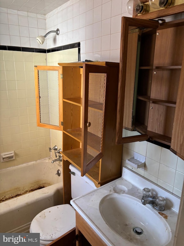 bathroom featuring vanity, tiled shower / bath combo, tile walls, and backsplash