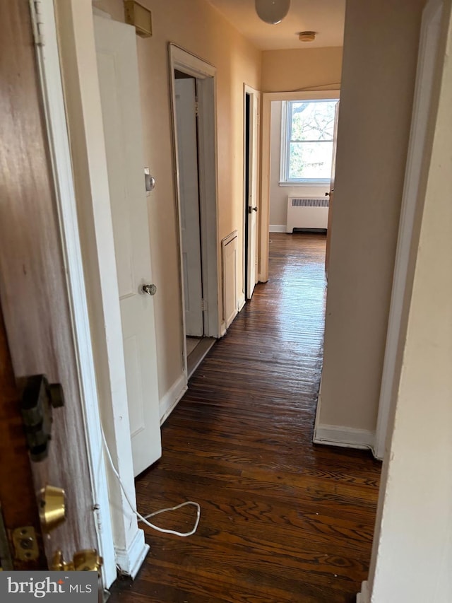 hall with dark wood-type flooring and radiator