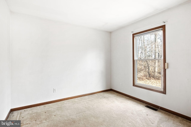 spare room featuring light colored carpet