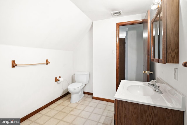 bathroom with vanity, toilet, and vaulted ceiling