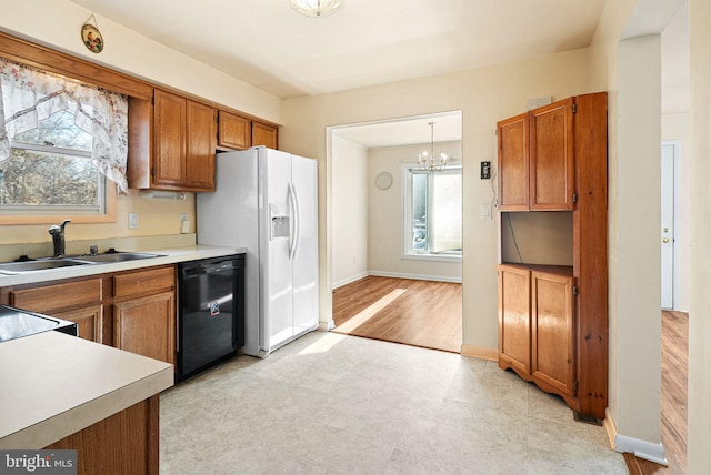 kitchen featuring sink, black dishwasher, pendant lighting, and plenty of natural light