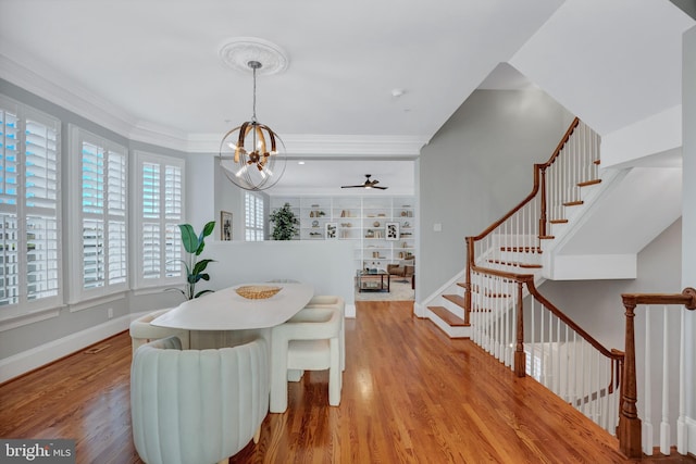 dining space featuring a notable chandelier, light hardwood / wood-style flooring, and ornamental molding